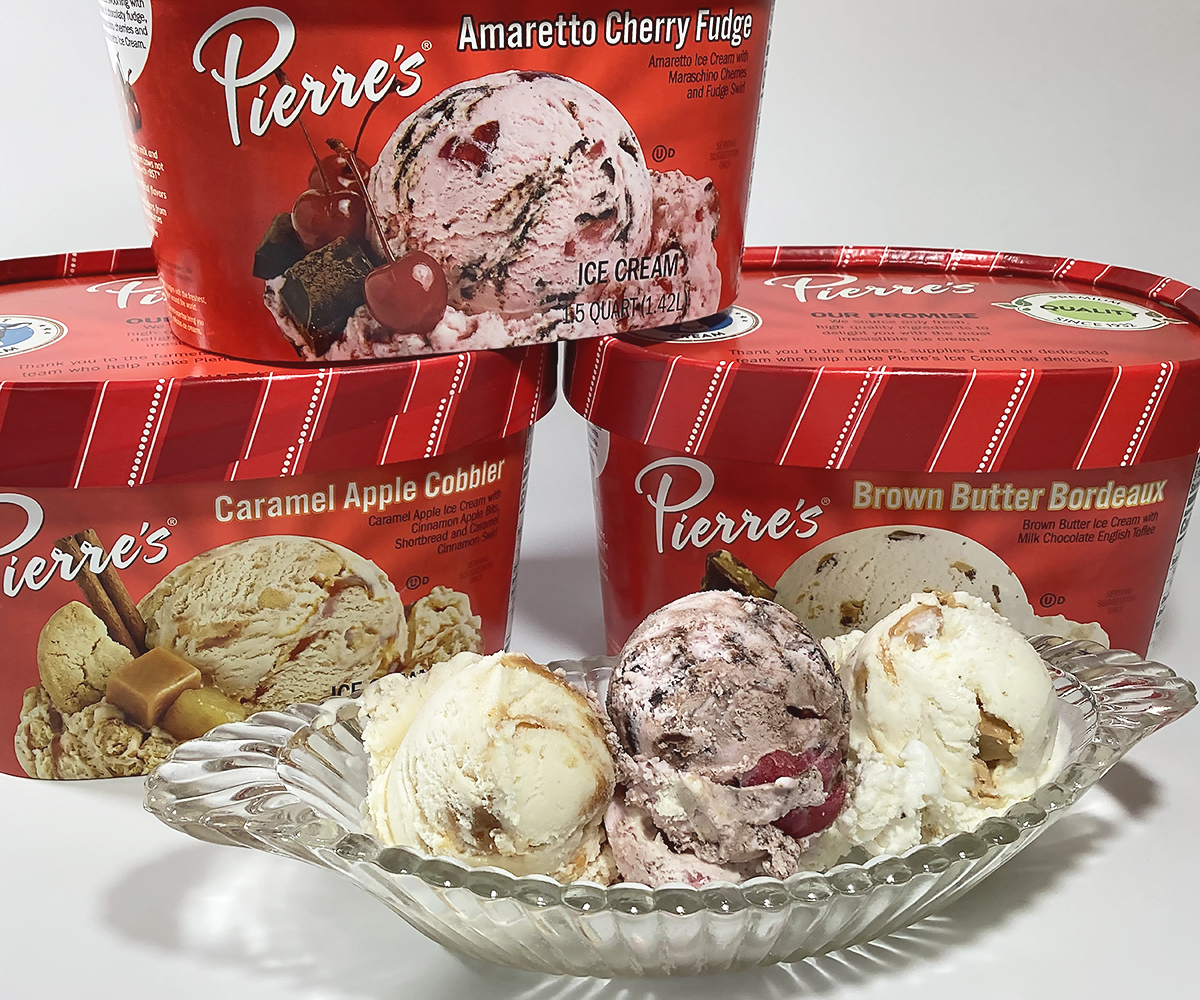 Three containers of Pierre's new ice cream flavors, Amaretto Cherry Fudge, Brown Butter Bordeaux and Caramel Apple Cobbler with scoops of all three flavors in an ice cream dish.